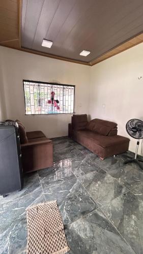 a living room with a couch and a tv at Pousada Green in Santarém