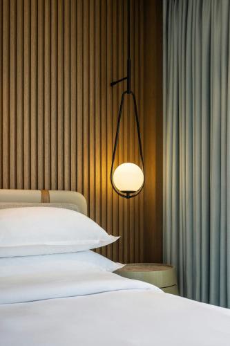a bedroom with a bed and a light fixture at Sheraton Grand Tel Aviv in Tel Aviv