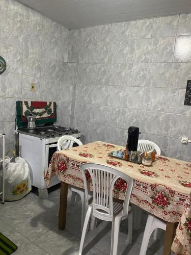 a kitchen with a table and chairs and a stove at Casa simples Natal Luz e FIG in Garanhuns