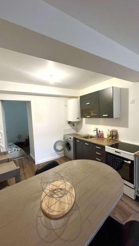 - une cuisine avec une table en bois dans une chambre dans l'établissement Le plein centre, à Montbrison