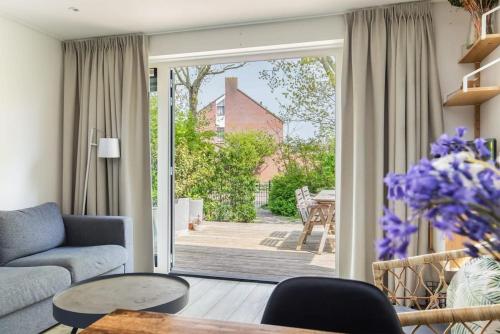 een woonkamer met een deur naar een patio bij Hello Zeeland - Vakantiehuis Duinenburg 22A in Domburg