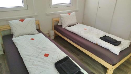 two beds in a small room with at ganzes Haus für dich 20min bis nach Interlaken und Adelboden in Frutigen