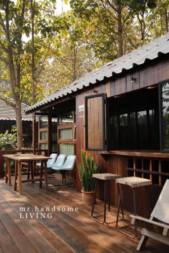 a building with tables and chairs on a wooden deck at mrhandsome phayao in Ban Mae Ka Hua Thung