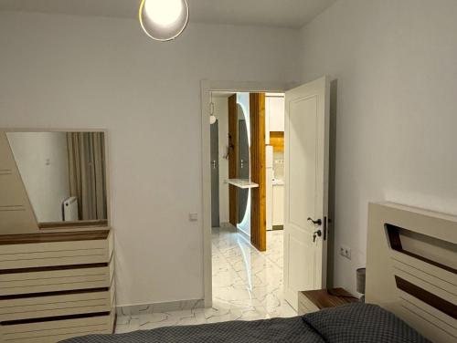 una camera da letto con un letto, un comò e uno specchio di White Bridge Riverside a Kutaisi