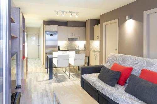 a living room with a couch and a kitchen at Terraza Privada I Refugio Tranquilo con Vistas in Canillo