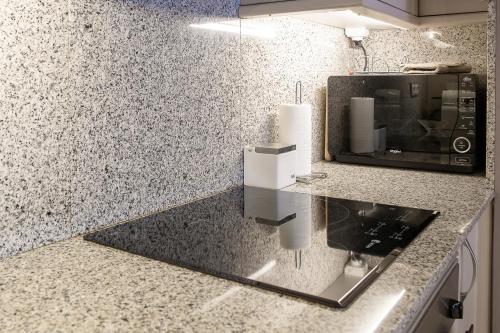 a kitchen with a counter top with a microwave at Terraza Privada I Refugio Tranquilo con Vistas in Canillo