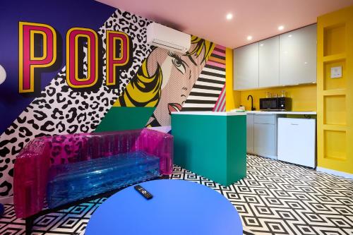 Il comprend un salon avec un canapé violet et une cuisine. dans l'établissement Appart InstaPOP'ART by La Villa Orange, à Carcassonne