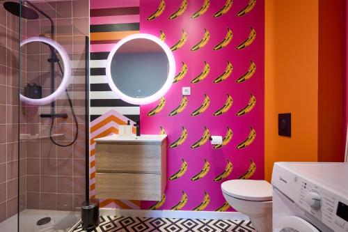 - une salle de bains dotée d'un mur rose avec des bananes dans l'établissement Appart InstaPOP'ART by La Villa Orange, à Carcassonne