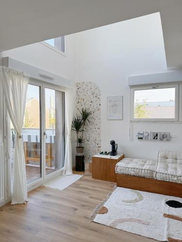 - un salon blanc avec un canapé et une fenêtre dans l'établissement Design Loft Disneyland Paris, à Bussy-Saint-Georges