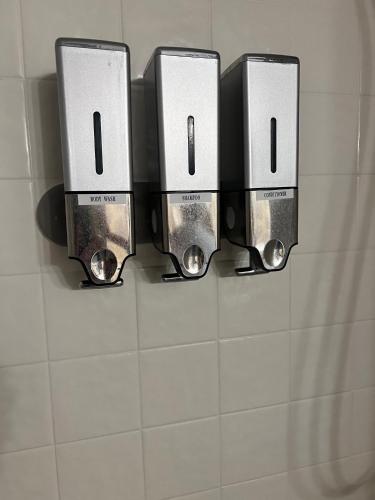 a row of soap dispensers on a bathroom wall at Huffman House Bed & Breakfast in Minden