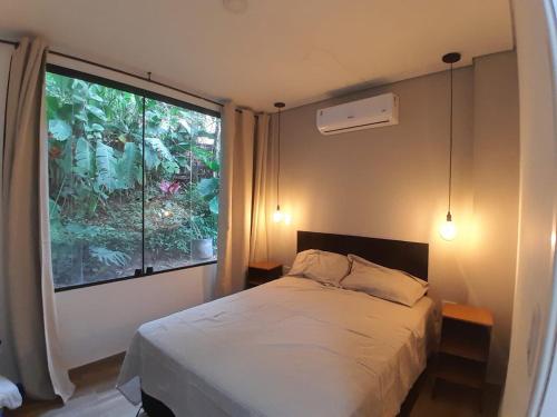 a bedroom with a bed and a large window at Casamar paraíso na praia com a vista do mar dos sonhos piscina e spa in Guarujá