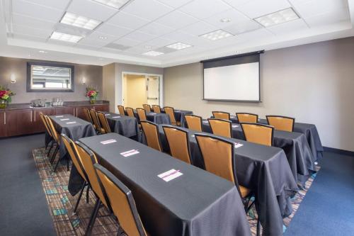 a conference room with tables and chairs and a screen at Residence Inn Phoenix NW/Surprise in Surprise