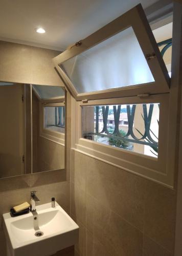 une salle de bain avec un lavabo et une grande fenêtre dans l'établissement Loft avec vue sur la Rade, à Villefranche-sur-Mer