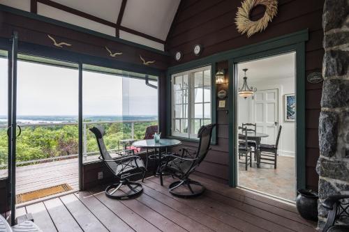 a screened in porch with a table and chairs at Far Horizons Luxury Vacation Home in Montebello