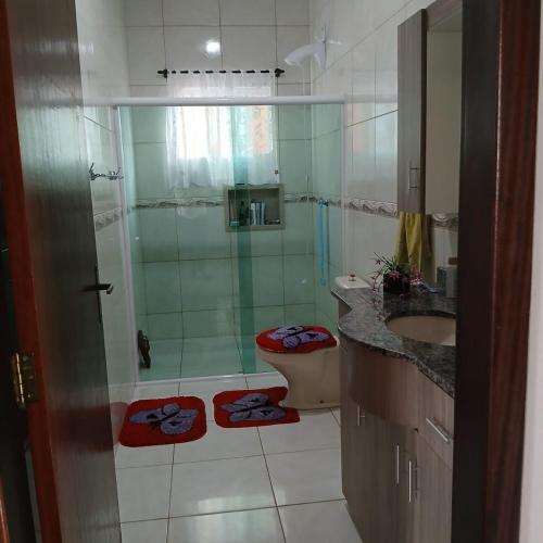 a bathroom with a shower and a toilet and a sink at Queiroz e Melânia in Penha