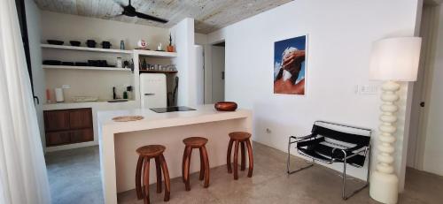a kitchen with a counter and stools in a room at Casa Remy - Walk to the Beach and stay in a private compound! Pool, Kitchen, AC, Wi-Fi in Mal País