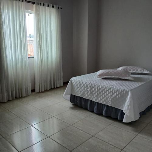 a bedroom with a bed and a window at Queiroz e Melânia in Penha