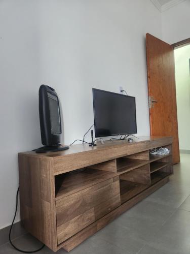 a television sitting on top of a wooden entertainment center at Sobrado novo e lindo com piscina in São José dos Campos