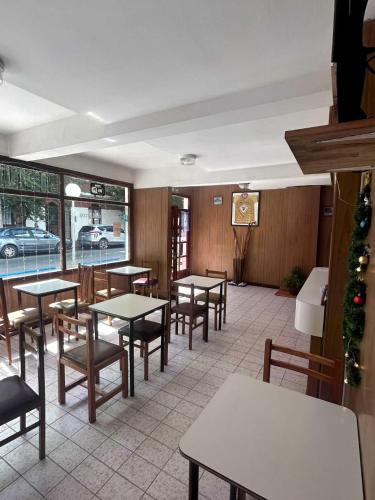 a restaurant with tables and chairs and a christmas tree at Hotel New SAN MARCOS in Mar de Ajó