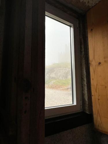 a window in a room with a view of a beach at Casa do Castelo in Trancoso