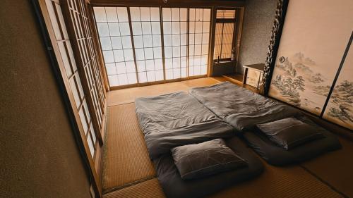 a small bed in a room with two pillows at Eastern sunrise home Valuable historical Japanese-style exclusive 4mins to ocean in Choshi