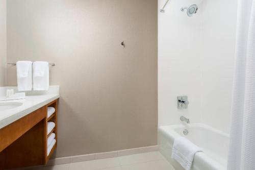 a white bathroom with a tub and a sink and a bath tubermott at SpringHill Suites by Marriott San Diego Mission Valley in San Diego