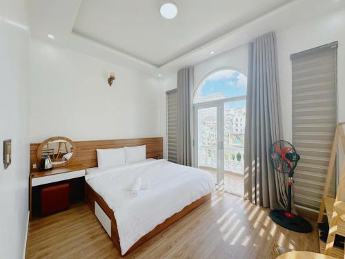a bedroom with a bed and a large window at Mai House Da Lat in Xuan An
