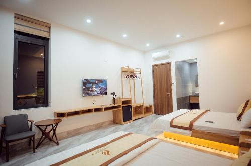 a bedroom with a bed and a desk and a tv at LINH CHI Hotel in Mỹ Lộc