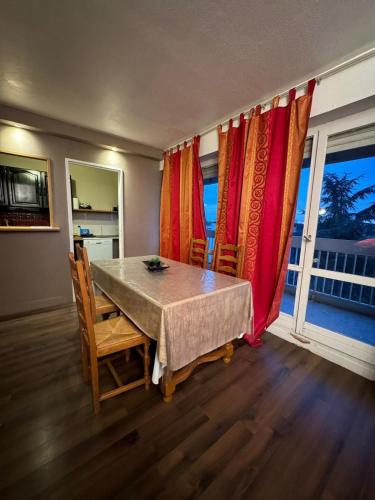 une salle à manger avec une table, des chaises et des fenêtres dans l'établissement Great apartment quiet neighborhood, à Élancourt