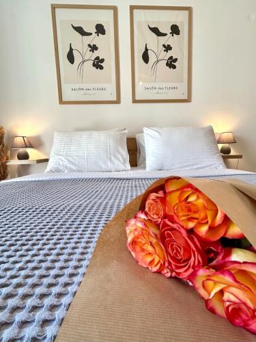a bed with flowers on it with two pictures on the wall at Casa de Memo in Agios Rokkos