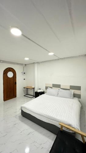 a bedroom with a large white bed in a room at Megun 10 L in Bangkok