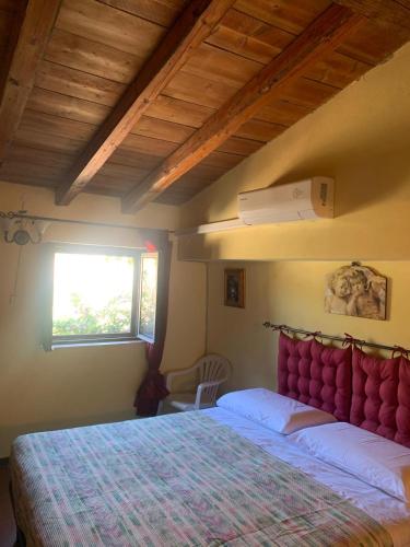 ein Schlafzimmer mit einem großen Bett mit rotem Kopfteil in der Unterkunft Case Troccoli in Caltabellotta