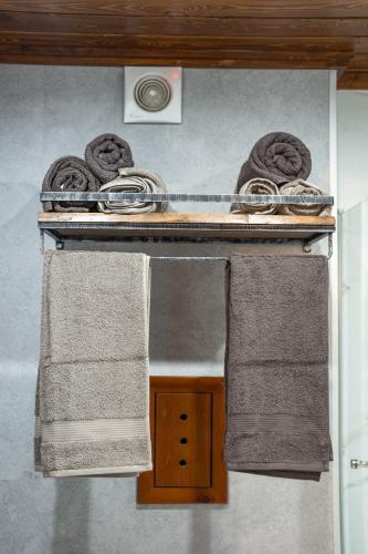 two towels on a shelf with two towels at Host2U Authentic Bansko Apartment - Free Parking in Bansko