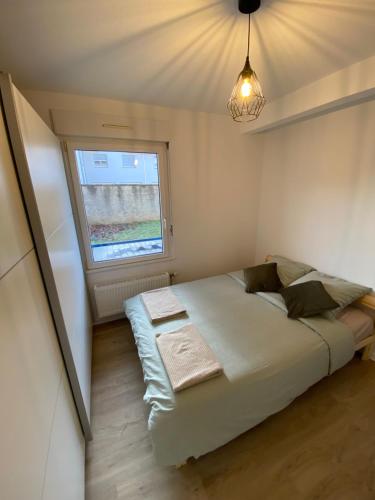 une petite chambre avec un lit et une fenêtre dans l'établissement Cocon au cœur de l'Alsace, à Horbourg-Wihr