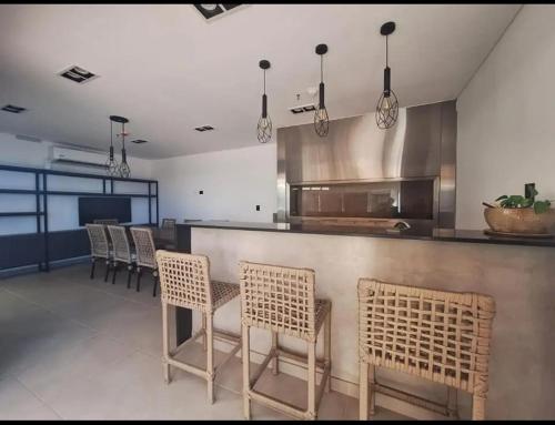 a kitchen with a bar with chairs and a counter at Departamento full a estrenar con wifi in Asuncion
