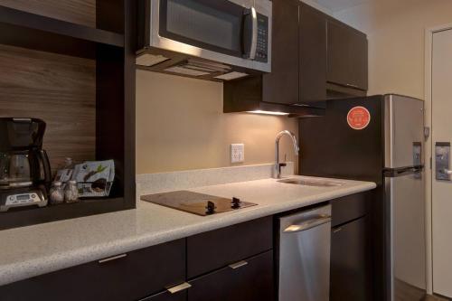 a kitchen with a sink and a microwave at TownePlace Suites by Marriott Austin Round Rock in Round Rock