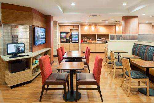 a restaurant with tables and chairs and a kitchen at TownePlace Suites by Marriott Austin Round Rock in Round Rock
