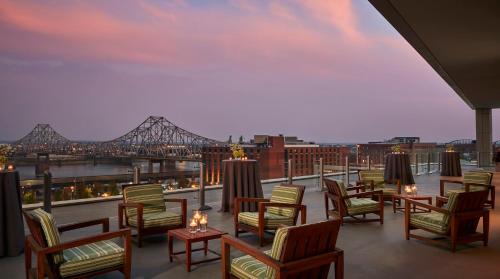 a balcony with chairs and tables and a view of a bridge at Four Seasons St. Louis in Saint Louis