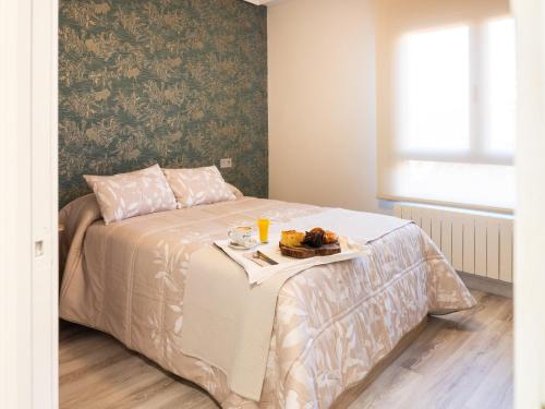 a bedroom with a bed with a tray of food on it at Apartamento Los Castillos 2I in Tordesillas