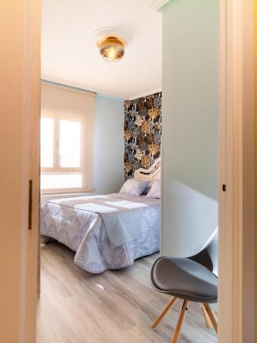 a bedroom with a bed and a chair at Apartamento Los Castillos 2I in Tordesillas