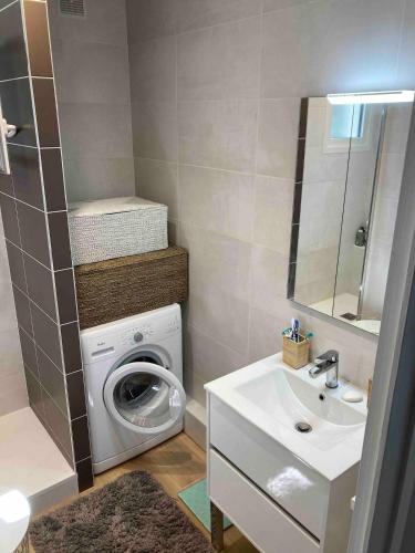 une salle de bain avec une machine à laver et un lavabo dans l'établissement Central, quiet not overlooked, à La Baule