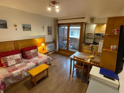 a room with a bed and a table and a kitchen at Studio Acacia Brides Les Bains in Brides-les-Bains