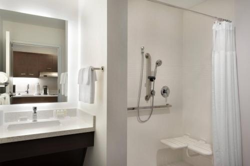 a white bathroom with a shower and a sink at TownePlace Suites by Marriott Joliet Minooka in Minooka