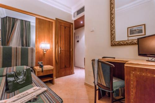 a room with a bed and a desk and a tv at Raeli Hotel Floridia in Rome