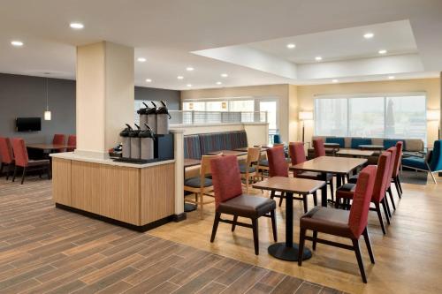 a restaurant with tables and chairs and a counter at TownePlace Suites by Marriott Joliet Minooka in Minooka