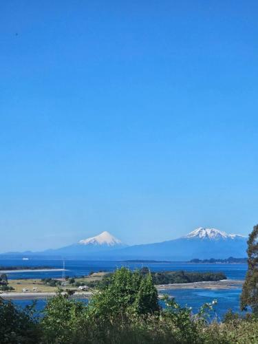 a view of snow capped mountains in the distance at Balcón del estero isla Puluqui in Calbuco
