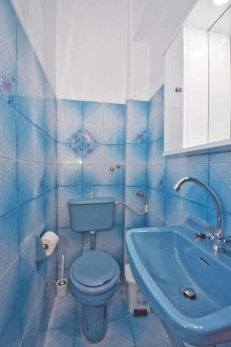 a blue bathroom with a toilet and a sink at KarolinaHouse in Ágios Matthaíos