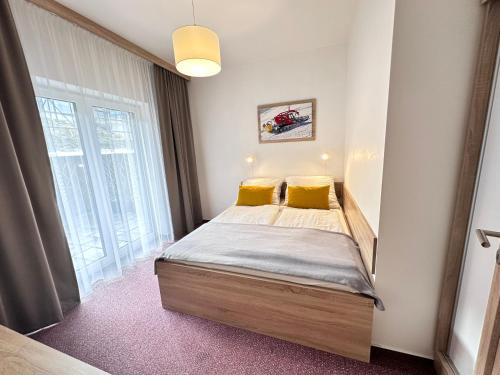 a small bedroom with a bed with yellow pillows at Apartmán Orech in Belá