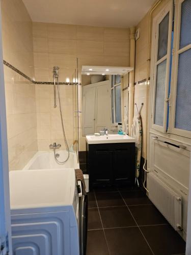 a bathroom with a white tub and a sink at Cosy private room in Shared appartment - 1 person only ! in Paris