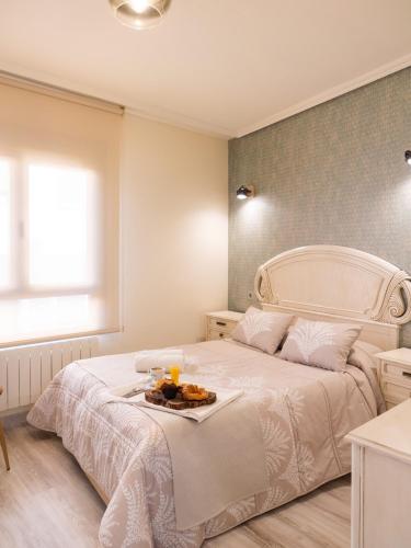 a bedroom with a bed with a tray of food on it at Apartamento Los Castillos 2D in Tordesillas
